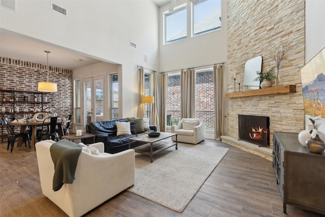 living area with a fireplace, visible vents, and a healthy amount of sunlight