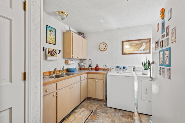 laundry room featuring independent washer and dryer, stone finish floor, a sink, a textured ceiling, and cabinet space