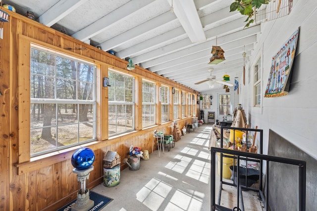 sunroom featuring beam ceiling and ceiling fan