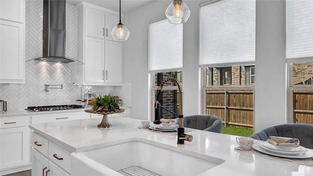 1017 Wrenwood Dr, Justin, TX 76247 - kitchen featuring wall chimney range hood, tasteful backsplash, white cabinetry, and stainless steel gas stovetop
