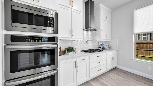 1017 Wrenwood Dr, Justin, TX 76247 - kitchen featuring light countertops, wall chimney exhaust hood, baseboards, tasteful backsplash, and appliances with stainless steel finishes
