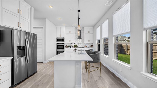 1017 Wrenwood Dr, Justin, TX 76247 - kitchen featuring visible vents, a breakfast bar area, stainless steel appliances, and a healthy amount of sunlight