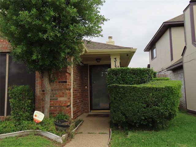 313 Conger Dr, Mesquite, TX 75149 - entrance to property with brick siding, a shingled roof, and a chimney