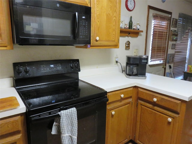 313 Conger Dr, Mesquite, TX 75149 - kitchen featuring brown cabinetry, open shelves, light countertops, black appliances, and a peninsula