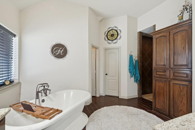 bathroom featuring a freestanding bath, a walk in shower, and wood finished floors