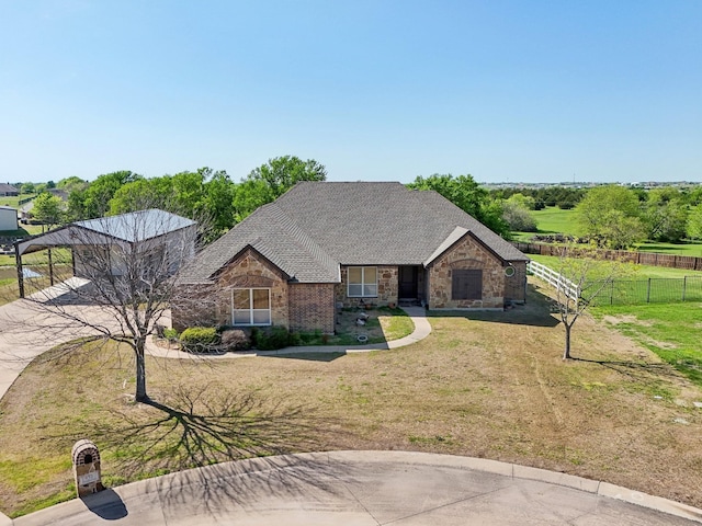 view of front of home featuring a shingled roof, stone siding, fence, and a front lawn
