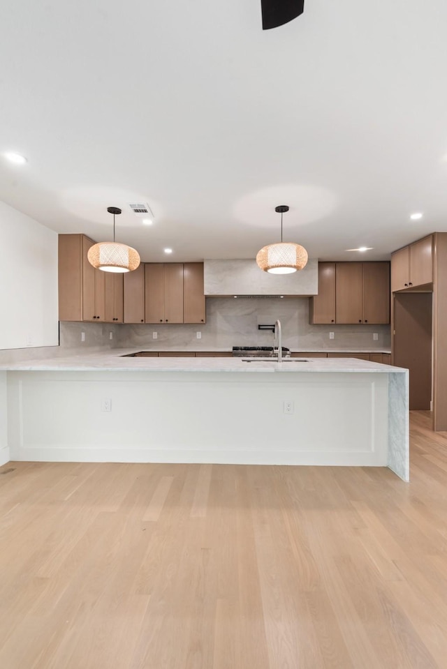 9805 Bluff Dale Dr, Dallas, TX 75218 - kitchen featuring a sink, backsplash, light countertops, and light wood-style flooring