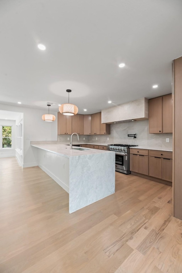 9805 Bluff Dale Dr, Dallas, TX 75218 - kitchen with high end stainless steel range, backsplash, light wood-style flooring, and a sink