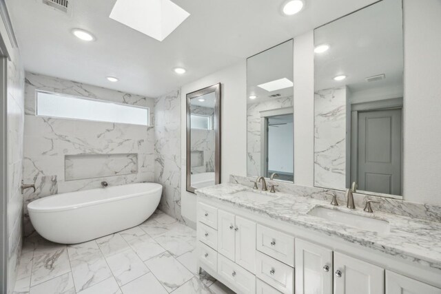 4108 Desert Garden Dr, Plano, TX 75093 - bathroom featuring a skylight, a freestanding tub, marble finish flooring, double vanity, and recessed lighting