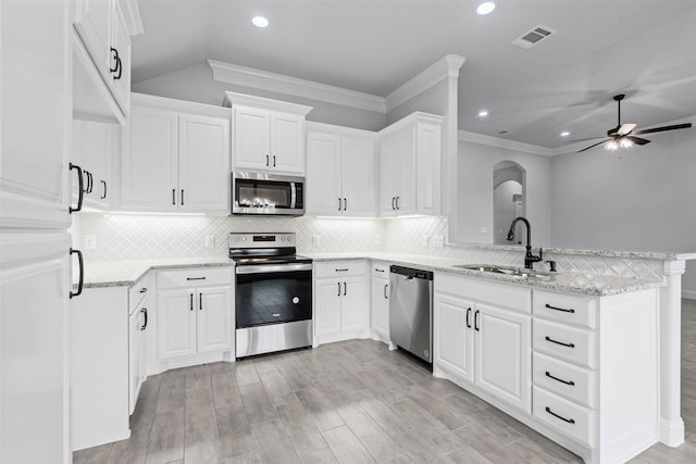 700 Jameson, Springtown, TX 76082 - kitchen with light wood-style flooring, a peninsula, appliances with stainless steel finishes, a sink, and light stone counters