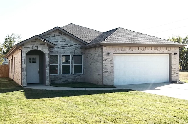 view of front facade featuring concrete driveway, a front lawn, a garage, and roof with shingles