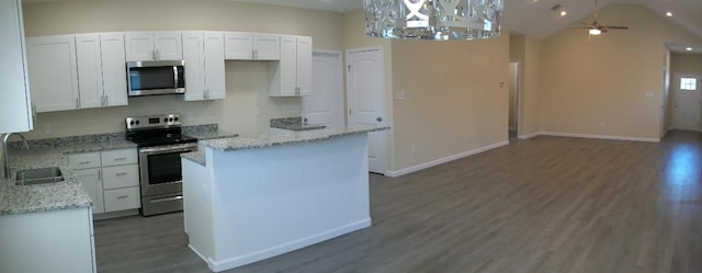 kitchen with a center island, ceiling fan, stainless steel appliances, wood finished floors, and white cabinetry
