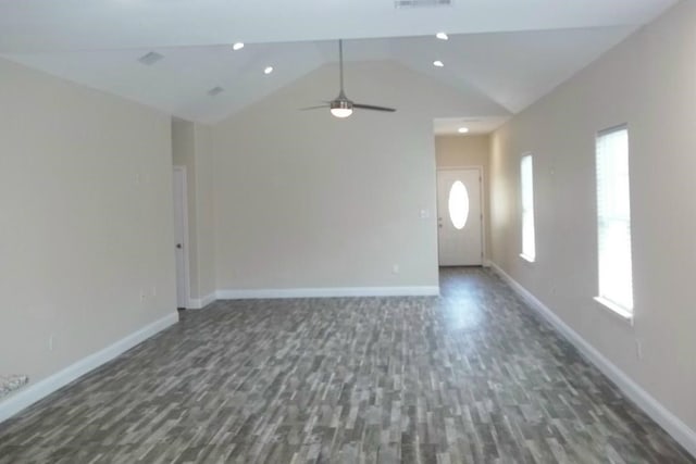 unfurnished living room featuring a wealth of natural light, vaulted ceiling, and wood finished floors