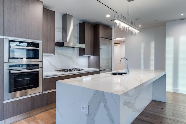 3130 N Harwood St Unit 1404, Dallas, TX 75201 - kitchen featuring wall chimney exhaust hood, modern cabinets, a sink, appliances with stainless steel finishes, and recessed lighting