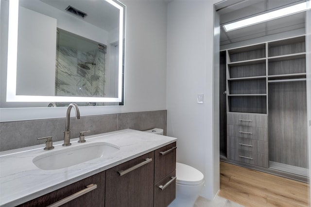 3130 N Harwood St Unit 1404, Dallas, TX 75201 - full bath featuring vanity, toilet, a shower, and wood finished floors