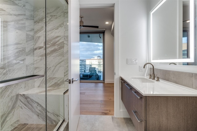 3130 N Harwood St Unit 1404, Dallas, TX 75201 - bathroom featuring vanity, a marble finish shower, wood finished floors, and recessed lighting