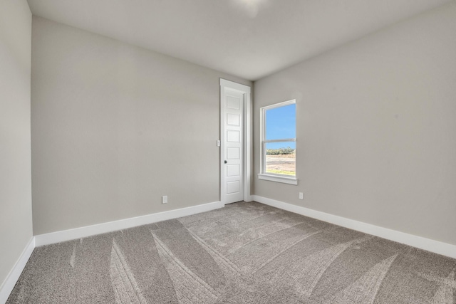unfurnished room featuring carpet flooring and baseboards
