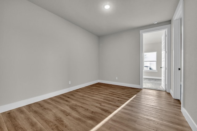 unfurnished room with baseboards and wood finished floors