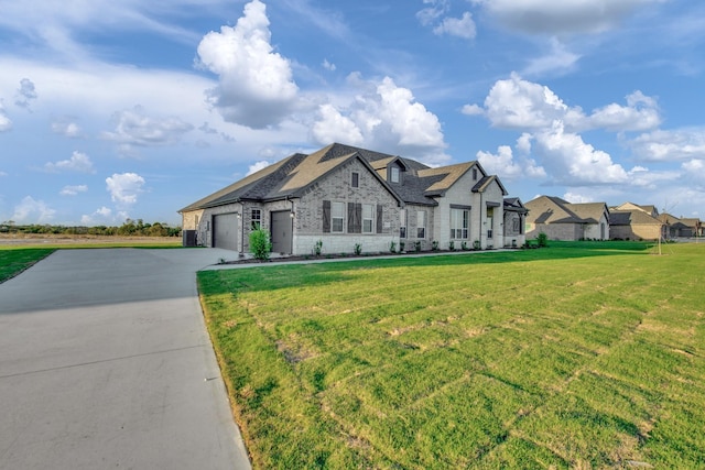 french country inspired facade featuring an attached garage, a front lawn, concrete driveway, stone siding, and brick siding