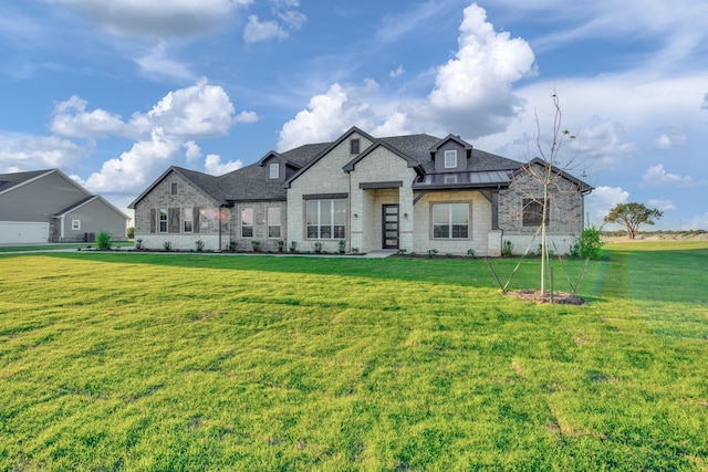 french country style house with brick siding and a front lawn