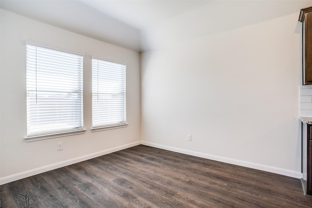unfurnished room featuring dark wood-style floors and baseboards