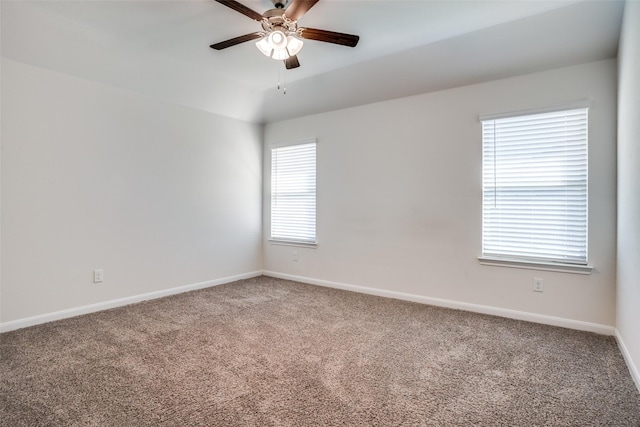 unfurnished room with carpet flooring, a ceiling fan, and baseboards