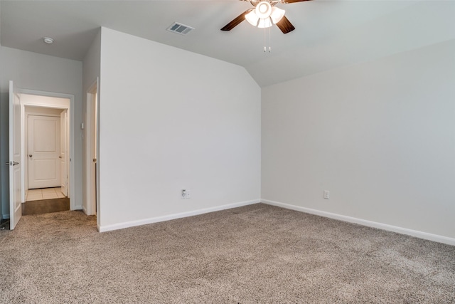unfurnished bedroom with visible vents, baseboards, lofted ceiling, and carpet floors