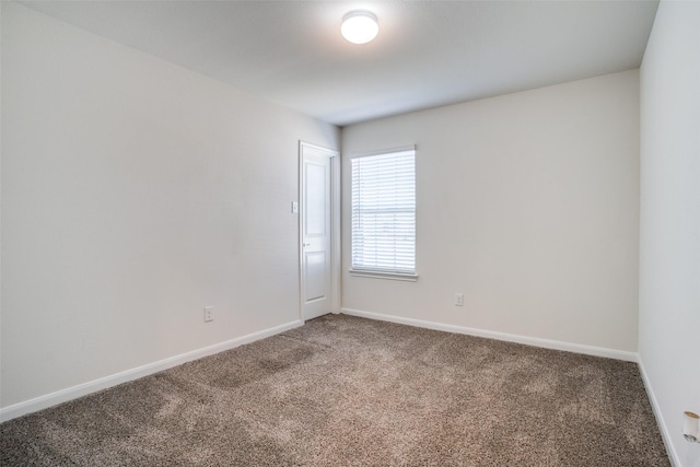 carpeted spare room featuring baseboards
