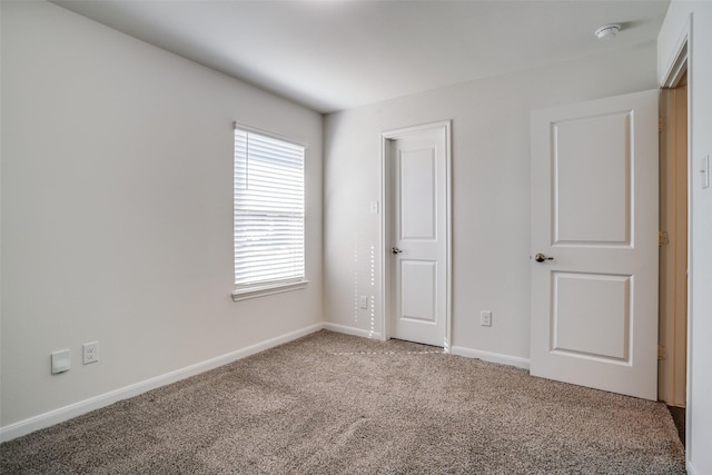 unfurnished bedroom featuring light colored carpet and baseboards