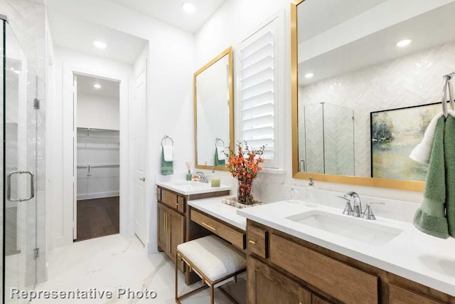 full bathroom featuring a spacious closet, recessed lighting, a stall shower, and a sink