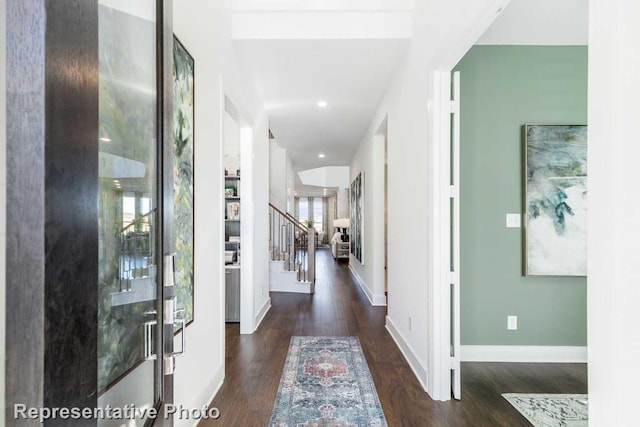 hallway with baseboards, recessed lighting, wood finished floors, and stairs