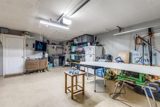 5805 Trail Crest Dr, Arlington, TX 76017 - garage featuring a garage door opener, freestanding refrigerator, and a workshop area
