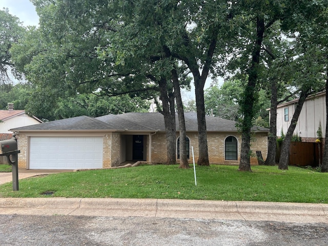 5805 Trail Crest Dr, Arlington, TX 76017 - view of front of home with an attached garage, a front lawn, brick siding, and driveway