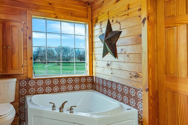full bathroom with wooden walls, toilet, and a garden tub