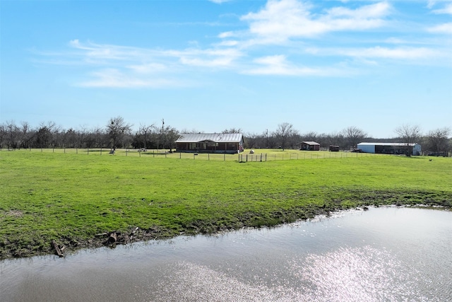 view of yard featuring a rural view, an outdoor structure, and fence