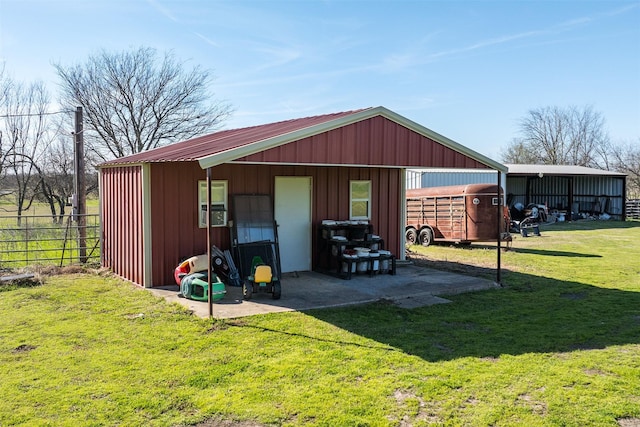 view of pole building featuring a yard and fence