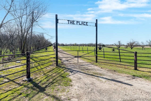 view of gate featuring a rural view and a yard