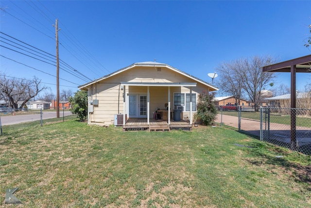 rear view of property with a lawn, central AC, and fence