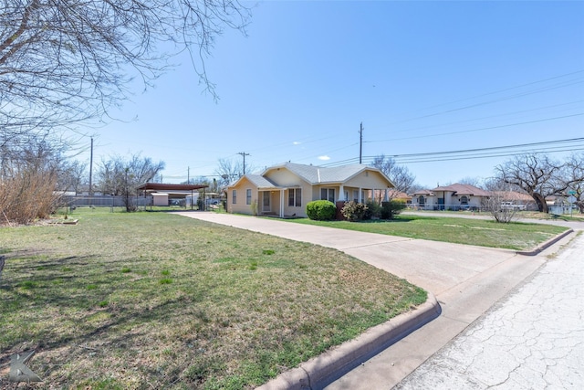 ranch-style home featuring a front yard, fence, driveway, and stucco siding