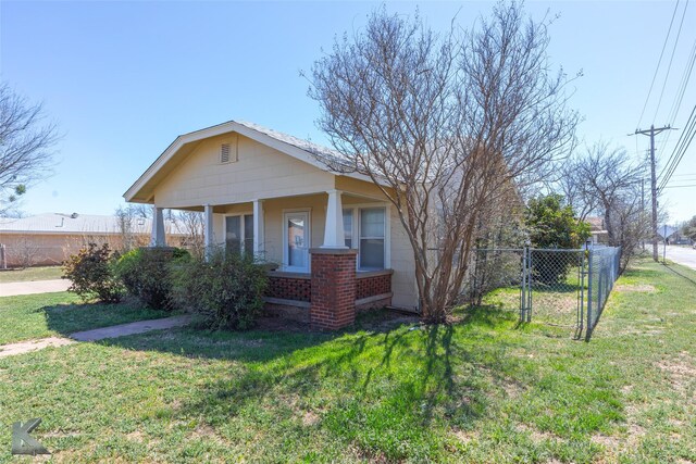 bungalow with a gate, a porch, fence, a front yard, and brick siding
