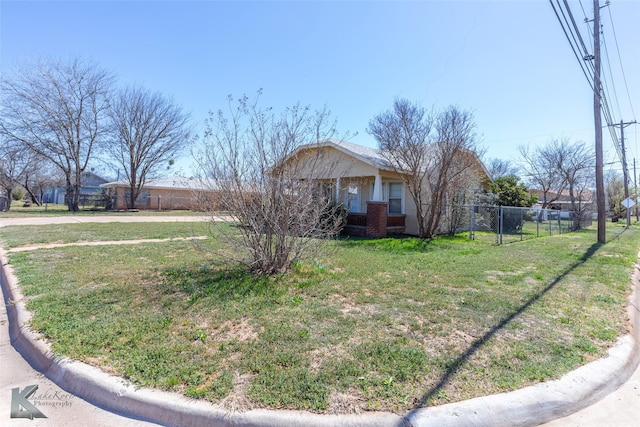 view of front of house with brick siding, a front yard, and fence