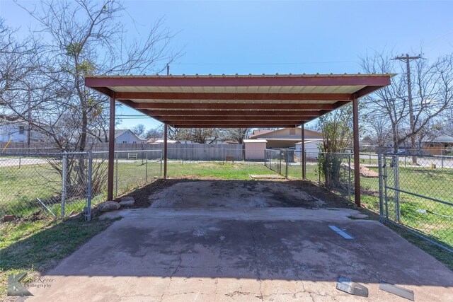 view of car parking featuring a carport, driveway, and fence