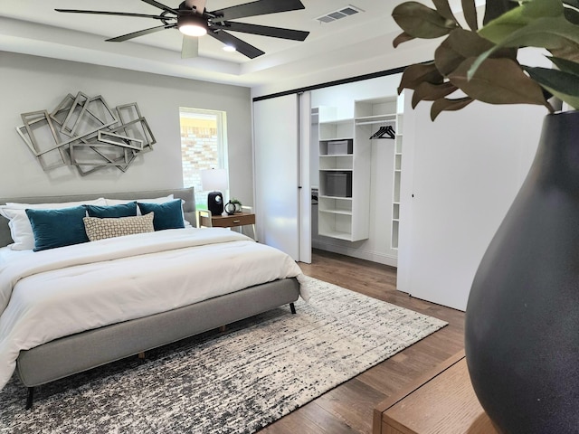 1105 Northpark Dr, Richardson, TX 75081 - bedroom with wood finished floors, a tray ceiling, and ceiling fan