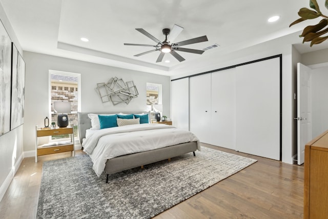1105 Northpark Dr, Richardson, TX 75081 - bedroom featuring multiple windows, wood finished floors, recessed lighting, a raised ceiling, and a closet