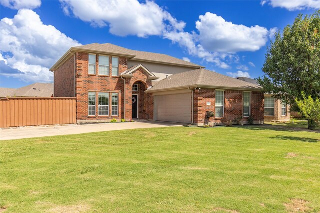 traditional-style house with brick siding, a garage, driveway, and a front lawn