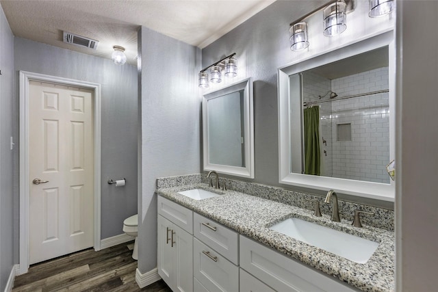 full bath with visible vents, toilet, wood finished floors, and a sink