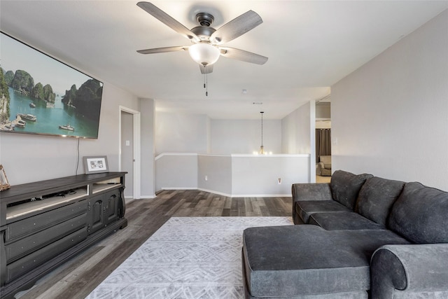 living room featuring baseboards, dark wood-type flooring, and a ceiling fan