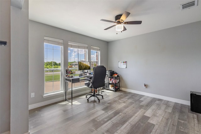 unfurnished office featuring visible vents, baseboards, a ceiling fan, and wood finished floors
