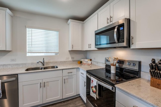 528 Lake Erie Dr, Princeton, TX 75407 - kitchen with dark wood-type flooring, white cabinetry, a sink, and appliances with stainless steel finishes