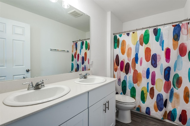 528 Lake Erie Dr, Princeton, TX 75407 - bathroom featuring double vanity, a sink, toilet, and wood finished floors